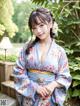 A woman in a blue kimono posing for the camera.