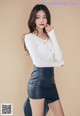 a woman in a white shirt and black skirt posing for a picture
