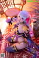 A woman in a bikini sitting on a rug next to a chair.