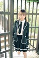 A young woman in a school uniform posing for a picture.