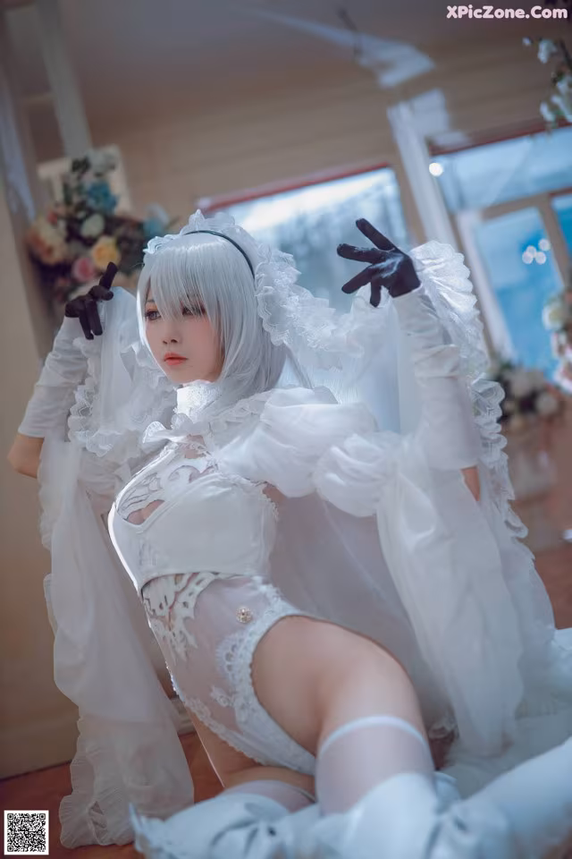 A woman in a white dress and black gloves posing for a picture.