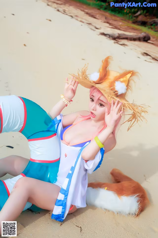 A woman in a bikini and a fox hat on the beach.