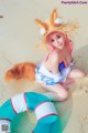 A woman in a bikini and a fox costume on the beach.