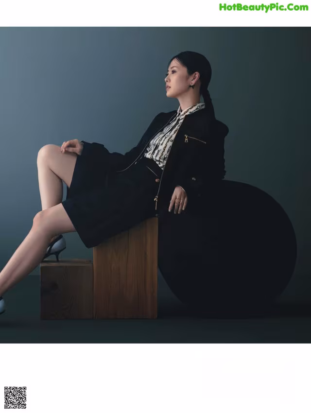 A woman sitting on top of a wooden box.