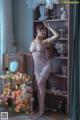A woman in a white lingerie posing in front of a mirror.