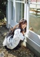 A woman crouching down in front of a door with a rabbit in the window.