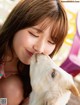 A young girl is kissing a goat on the cheek.