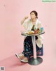 A woman sitting at a table eating a bowl of food.