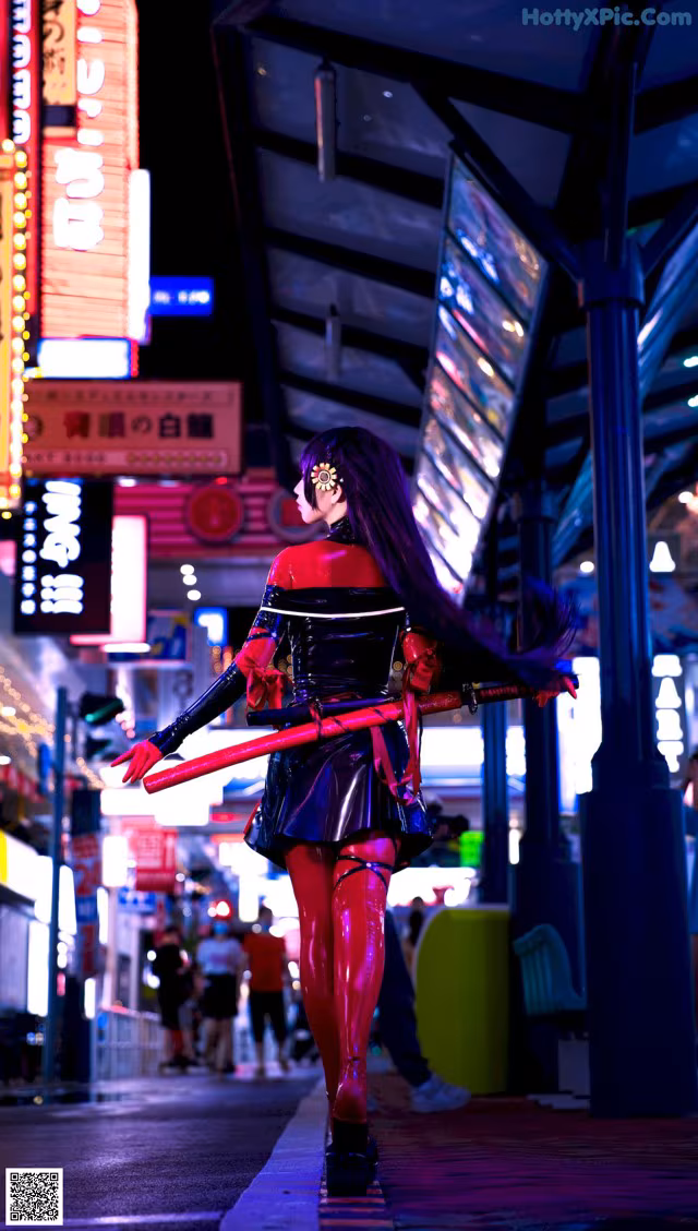 A woman in a red and black outfit holding a sword.