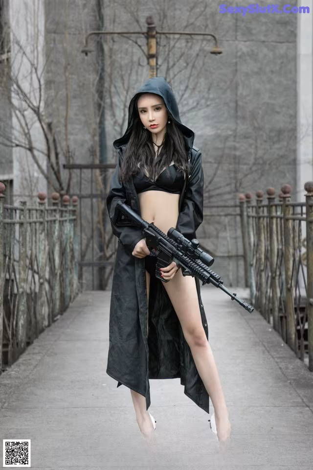 A woman in a black outfit holding a rifle.